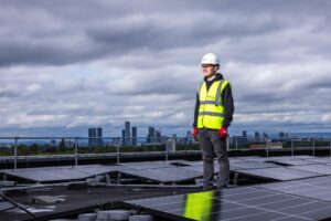 engineer standing on top of building surrounded by solar panels