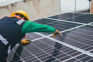 engineer fitting solar panels on a house roof